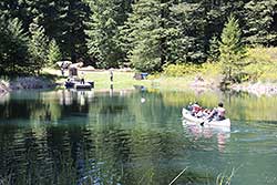 Four kids canoeing back to start