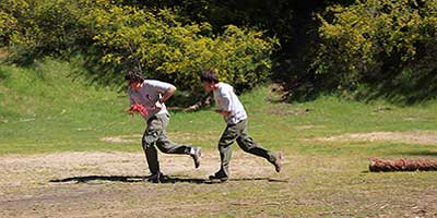 Boys running pulling a log